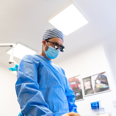 Dr George Karageorgiou in a surgical gown and loupes