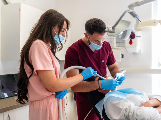 A dentist and dental nurse treating a patient in the chair